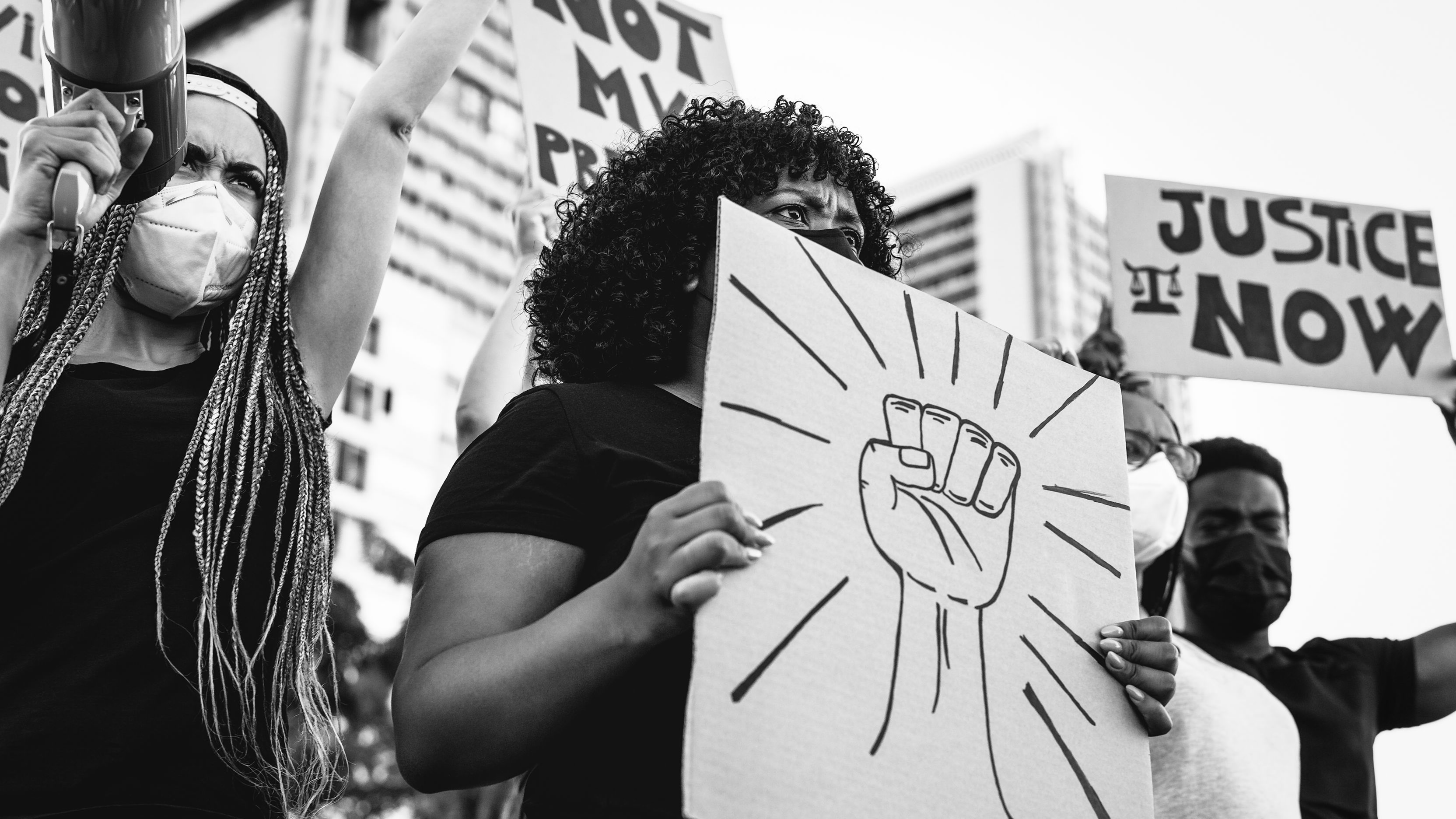 Protestors hold pro-racial justice signs at a rally.